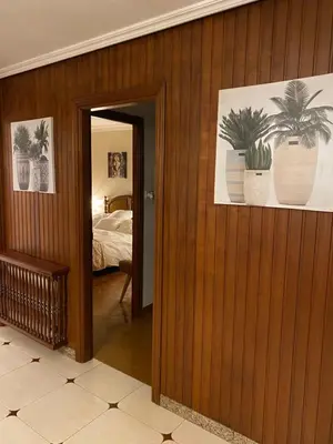 a hallway leading to a bedroom with potted plants on the wall at ACASADACONCHA in Moeche