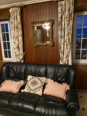 a black leather couch in a room with windows at ACASADACONCHA in Moeche
