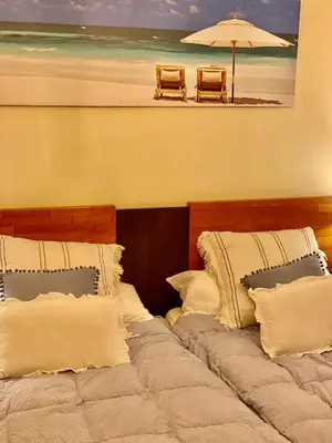 a bedroom with two beds with an umbrella and a beach at ACASADACONCHA in Moeche