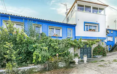 a blue and white house with plants at Beautiful Home In Diomondi With Wifi in Diomondi