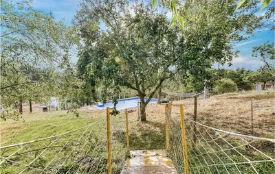 a fence with a tree in a field at Beautiful Home In Diomondi With Wifi in Diomondi