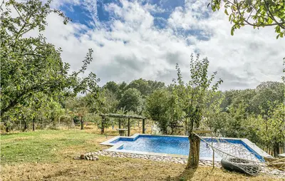 a swimming pool in a field with a tree at Beautiful Home In Diomondi With Wifi in Diomondi