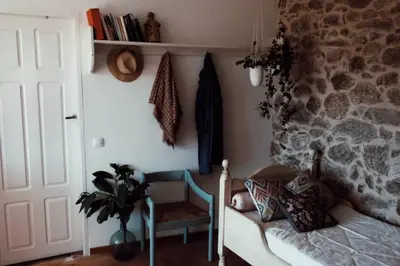 a bedroom with a couch and a stone wall at El Escondite Inglés in Pantón