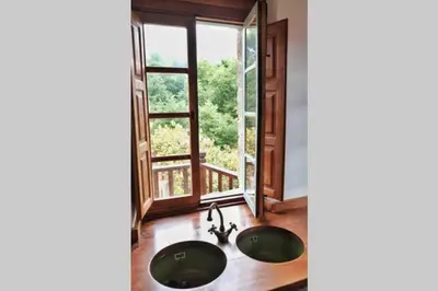 a bathroom with two sinks in front of a window at El Escondite Inglés in Pantón