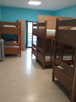 a room with several bunk beds in a room at Albergue La Plaza in Tineo