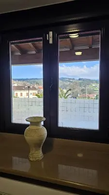 a vase sitting on a table in front of two windows at Casa de piedra, A Lameira in A Coruña