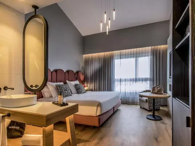 a bedroom with a bed and a sink and a mirror at Mercure Lugo Centro in Lugo
