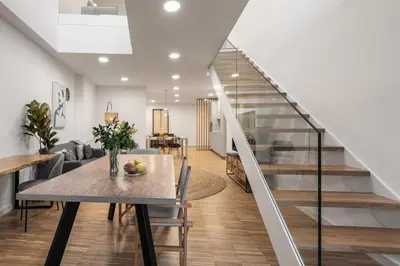 a dining room with a table and a staircase at I Loft Santiago by Upper Luxury Housing in Santiago de Compostela