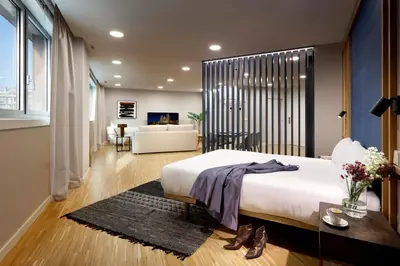 a bedroom with a large bed and a living room at I Loft Santiago by Upper Luxury Housing in Santiago de Compostela
