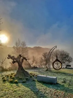 a painting of a tree and a sculpture in a field at Cabanas Mirador Cachamuíña in Ourense