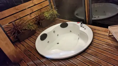 a bathroom with a white sink and a bath tub at Cabanas Mirador Cachamuíña in Ourense