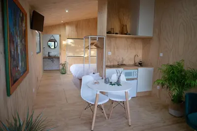 a kitchen and dining room with a white table and chairs at Cabanas Mirador Cachamuíña in Ourense