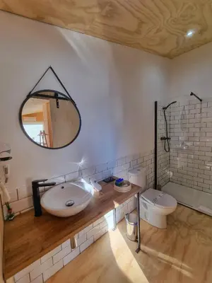 a bathroom with a sink and a mirror and a toilet at Cabanas Mirador Cachamuíña in Ourense