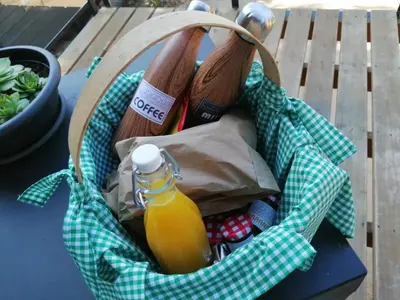 a picnic basket with a bottle of orange juice at Cabanas Mirador Cachamuíña in Ourense
