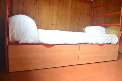a bed in a room with a wooden wall at Cabañas bungalow, El Bosque de los Sueños in Cubillos del Sil
