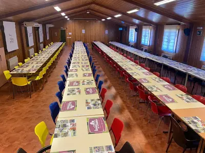 a long row of tables in a room with chairs at Cabañas bungalow, El Bosque de los Sueños in Cubillos del Sil