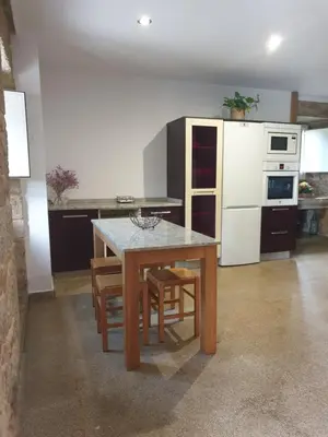 a kitchen with a table and chairs and a refrigerator at Villa Rosa in Silleda