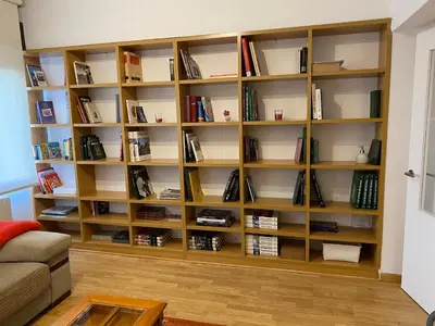 a book shelf filled with books in a living room at CERCA DE TODO in Santiago de Compostela