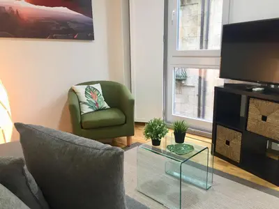 a living room with a couch and a chair and a tv at Catedral Centro Histórico in Ourense