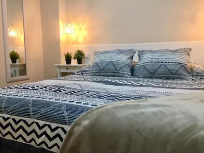 a bed with blue and white sheets and pillows at Catedral Centro Histórico in Ourense