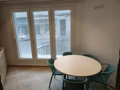 a table and chairs in a room with a window at A Pousa do Asma in Chantada