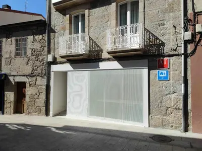 a white garage door with two balconies on a building at A Pousa do Asma in Chantada