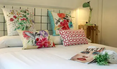 a bed with pillows and a magazine on it at Apartamentos LÓRIEN Milladoiro in Milladoiro