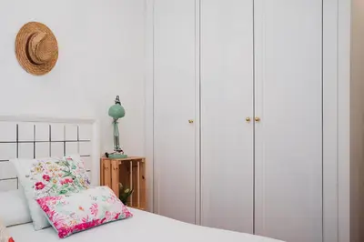a bedroom with white cabinets and a bed with a pillow at Apartamentos LÓRIEN Milladoiro in Milladoiro