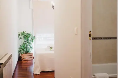 a white hallway with a table in a room at Apartamentos LÓRIEN Milladoiro in Milladoiro