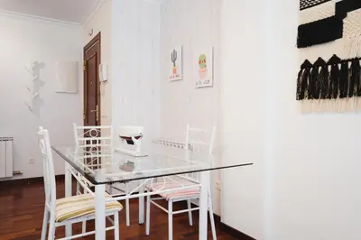 a dining room with a glass table and chairs at Apartamentos LÓRIEN Milladoiro in Milladoiro
