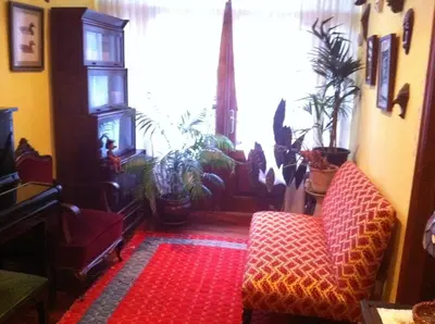 a living room with plants and a chair and a window at Casa das Augas Santas in Aguas Santas