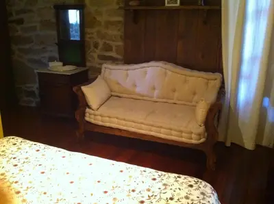 a white couch in a room with a bed at Casa das Augas Santas in Aguas Santas