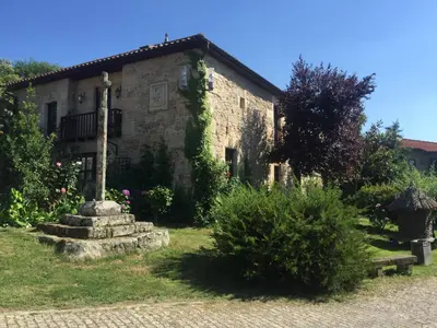 an old stone house with a garden in front of it at Casa das Augas Santas in Aguas Santas