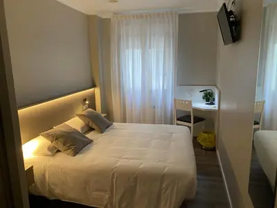 a hotel room with a bed and a desk at Villa Alta in Villalba