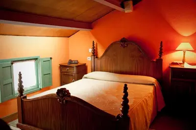 a bedroom with a large bed with an orange wall at Casa Don Din in Cruces