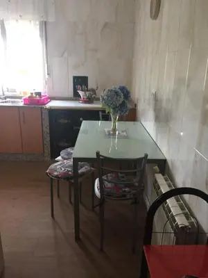 a table and chairs with a vase of flowers on it at Casa Campanita in Ribadeo