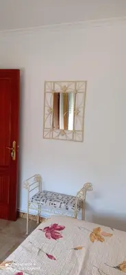 a room with a mirror and a bench and a table at Casa Campanita in Ribadeo