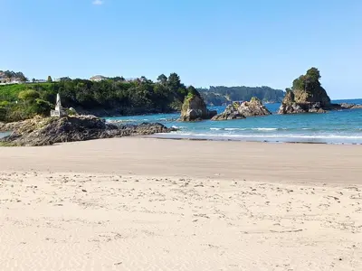 a sandy beach with rocks in the water at Indiano 2K in Viveiro