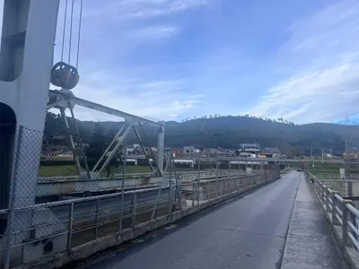 a bridge over a road with a mountain in the background at A casa do teléfono in Pumares