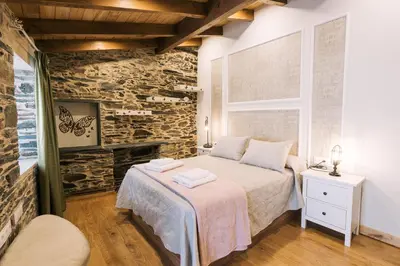 a bedroom with a bed and a stone wall at casa boral in Doade