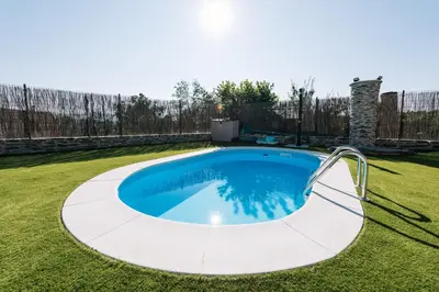 a large swimming pool in a yard with grass at casa boral in Doade