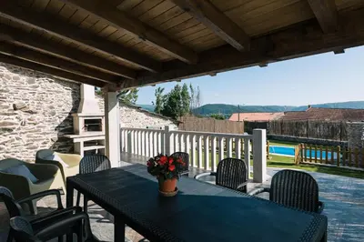 a table and chairs on a patio with a blue table at casa boral in Doade