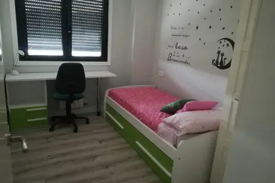a bedroom with a bed with a desk and a chair at Apartamento en ribeira sacra. Chantada in Chantada