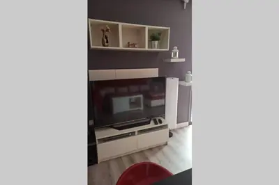 a living room with a television and a red chair at Apartamento en ribeira sacra. Chantada in Chantada