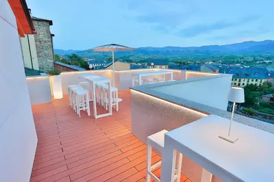 a balcony with tables and chairs on a building at Azotea Suites in Ponferrada