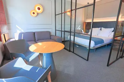 a hotel room with a bed and a table and a bedroom at Azotea Suites in Ponferrada