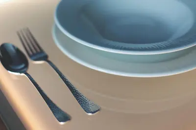 a table with a plate and a spoon and fork at Azotea Suites in Ponferrada