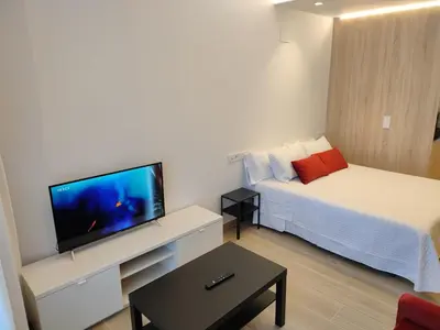 a small hotel room with a bed and a flat screen tv at Apartamentos A pousa do Asma in Chantada
