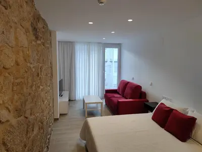 a hotel room with a bed and a red couch at Apartamentos A pousa do Asma in Chantada