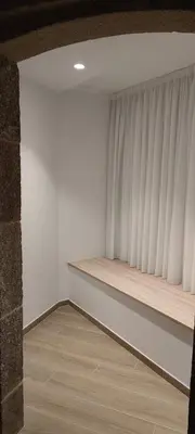 a room with white walls and a shelf with a window at Apartamentos A pousa do Asma in Chantada